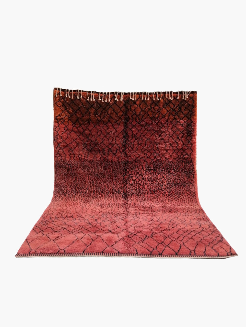 A deep red, traditional Berber-style Moroccan rug with visible natural wool fibers and a fringed edge.